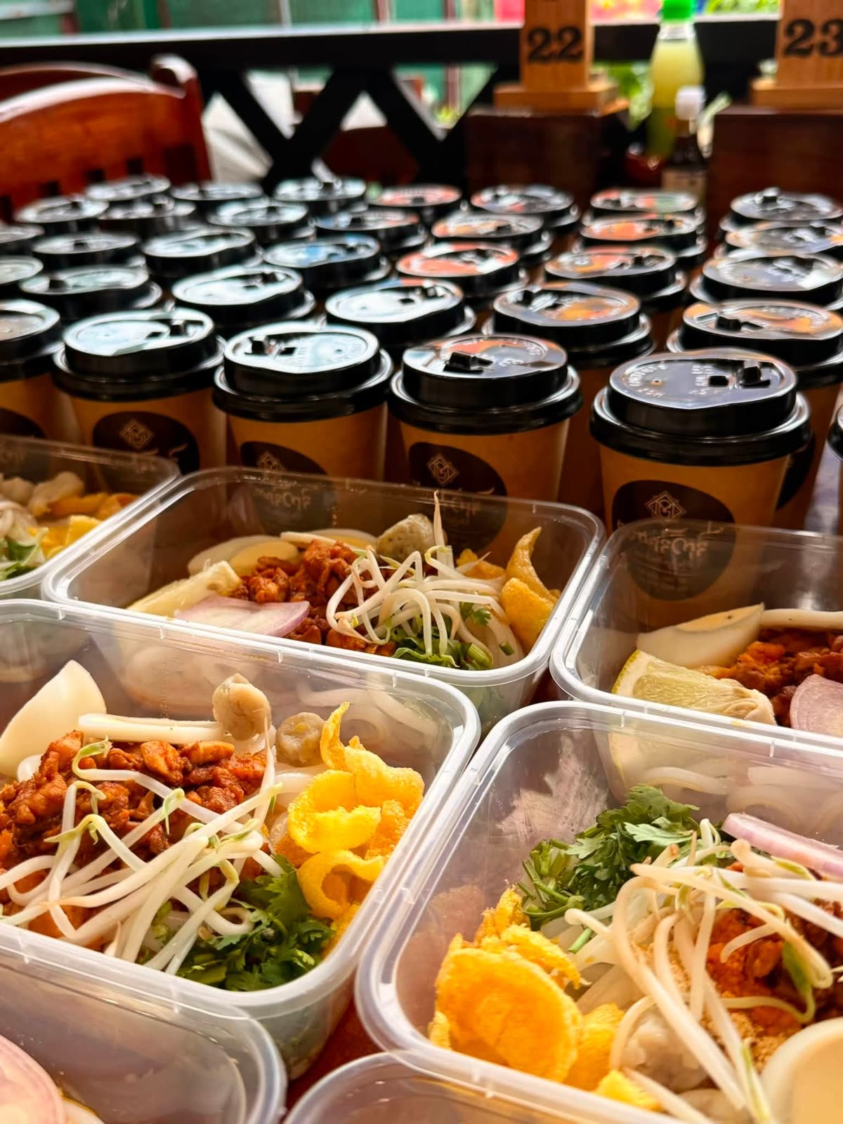 Rows of packed catering boxes and branded takeaway cups